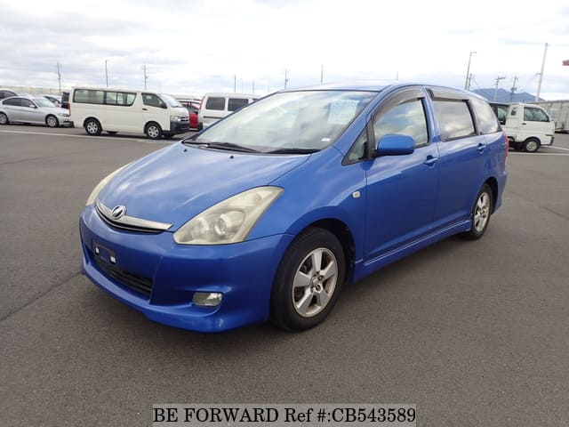 A grey JDM sports car speeding down a highway at night.