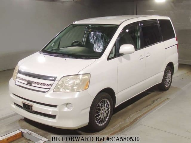 A grey JDM sports car speeding down a highway at night.