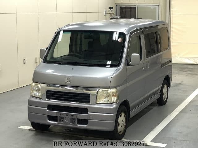 A grey JDM sports car speeding down a highway at night.