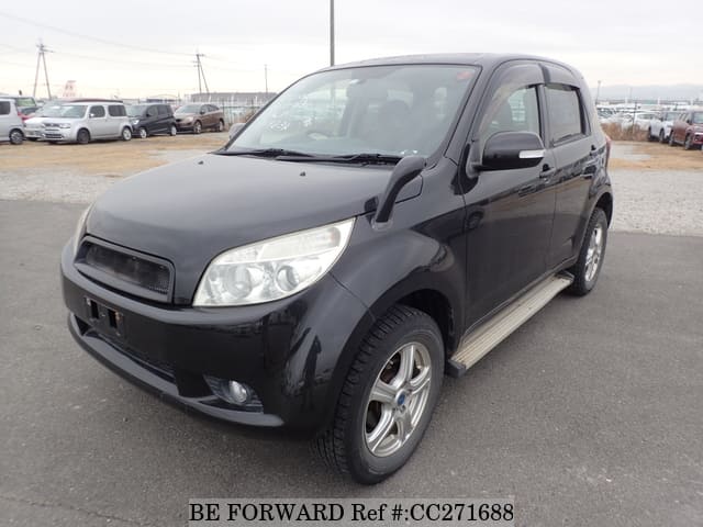 A grey sports car speeding down a highway at night.