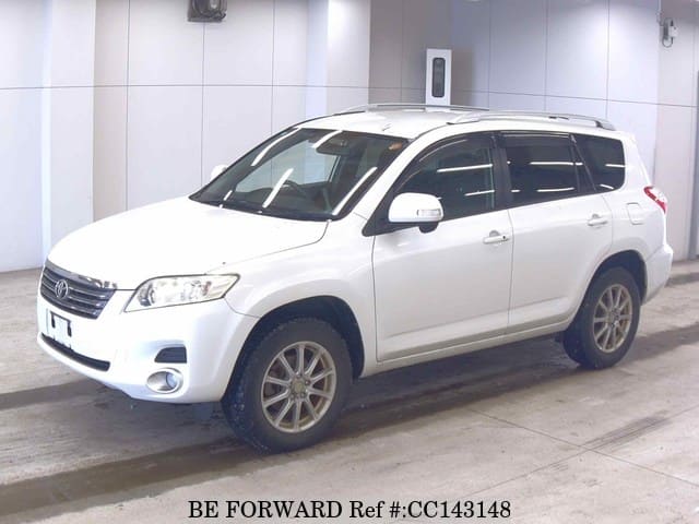 A grey sports car speeding down a highway at night.