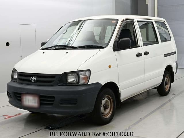 A grey JDM sports car speeding down a highway at night.
