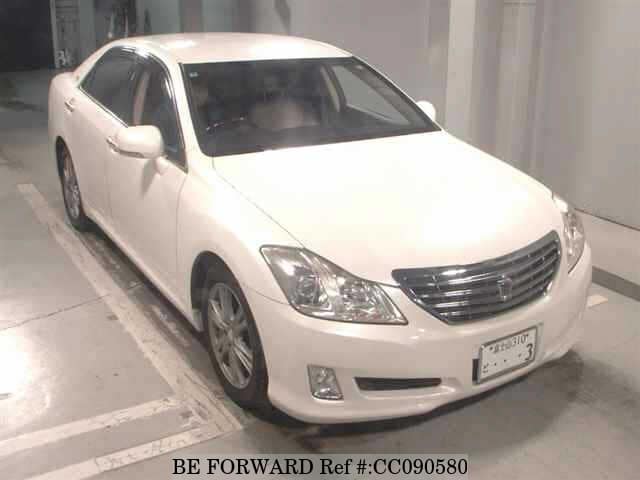 A grey sports car speeding down a highway at night.