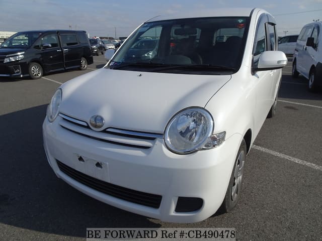A grey JDM sports car speeding down a highway at night.