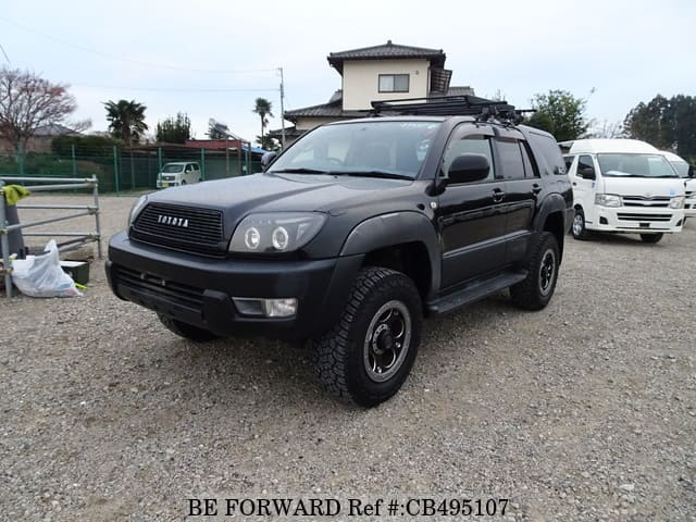 A grey JDM sports car speeding down a highway at night.
