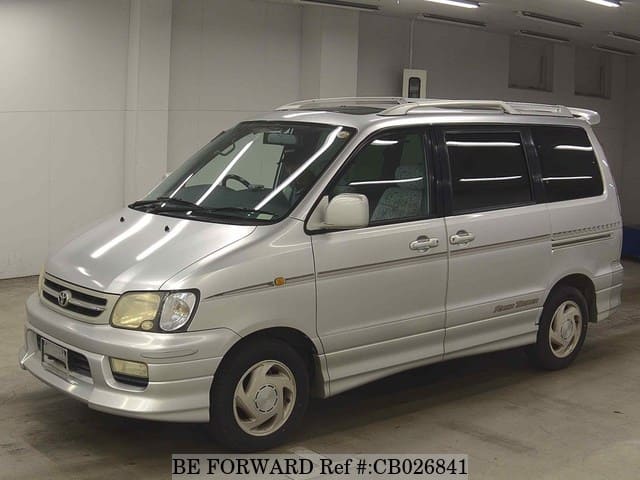A grey JDM sports car speeding down a highway at night.