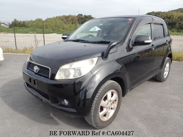 A grey JDM sports car speeding down a highway at night.