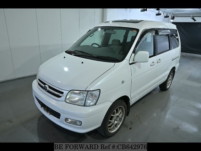 A grey JDM sports car speeding down a highway at night.