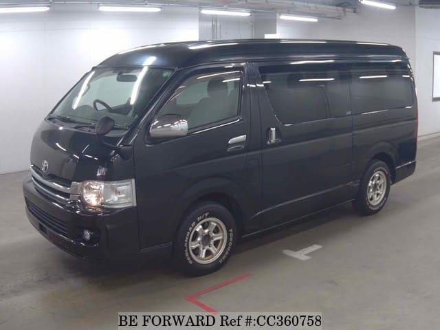 A grey sports car speeding down a highway at night.