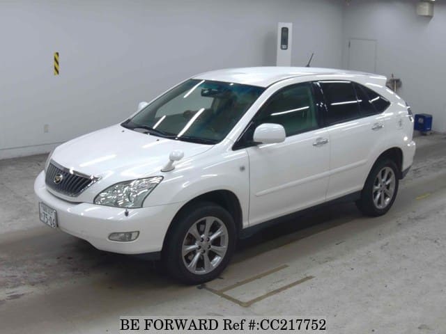 A grey sports car speeding down a highway at night.