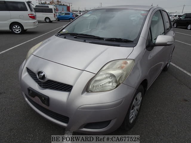 A grey JDM sports car speeding down a highway at night.