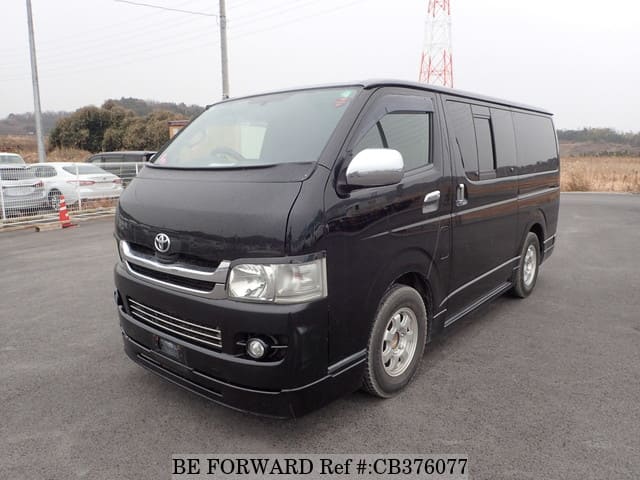 A grey JDM sports car speeding down a highway at night.