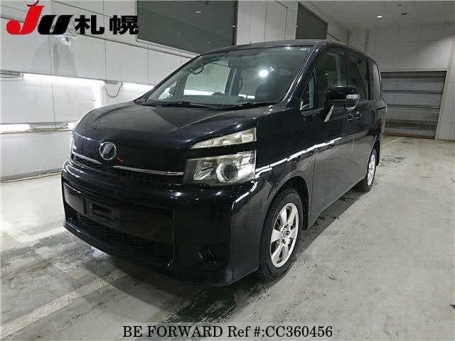 A grey sports car speeding down a highway at night.