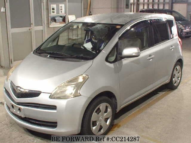 A grey sports car speeding down a highway at night.