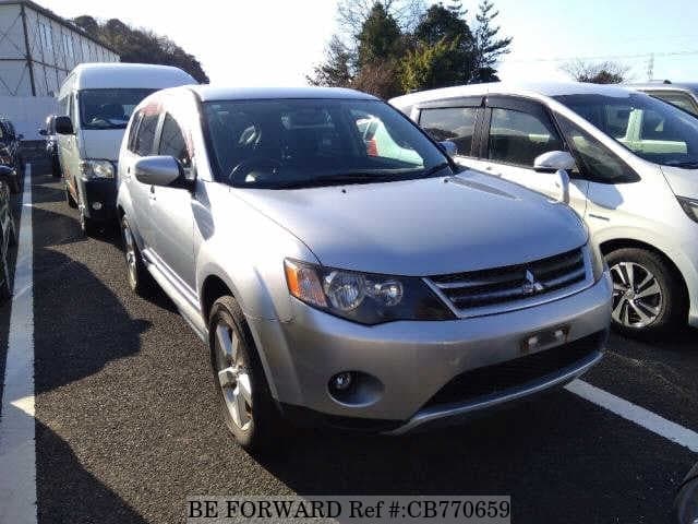 A grey JDM sports car speeding down a highway at night.