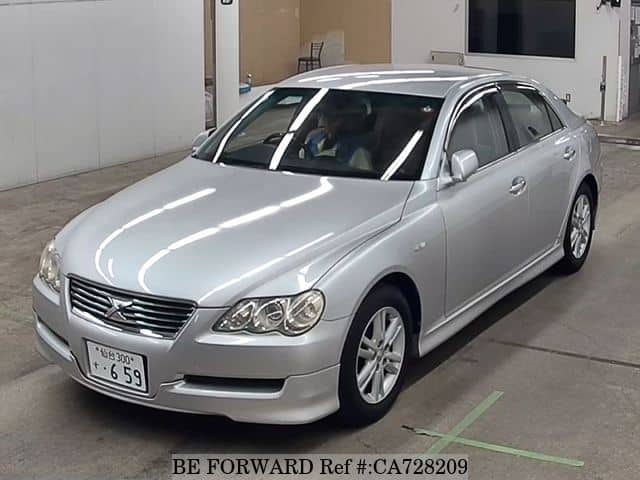 A grey JDM sports car speeding down a highway at night.
