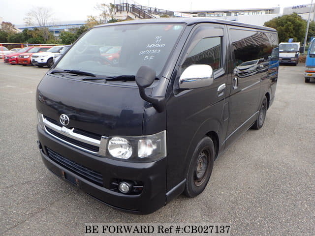 A grey sports car speeding down a highway at night.