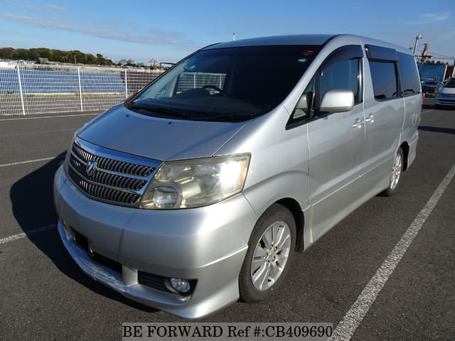 A grey JDM sports car speeding down a highway at night.