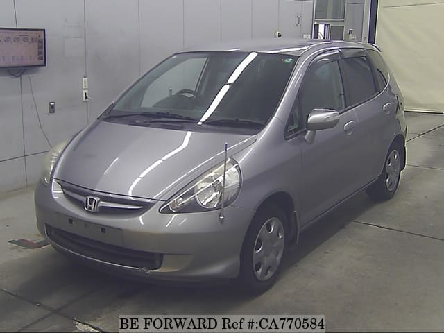 A grey JDM sports car speeding down a highway at night.