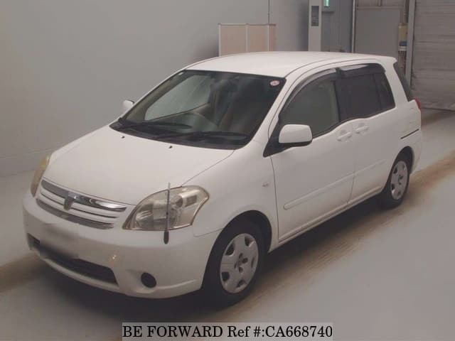 A grey JDM sports car speeding down a highway at night.