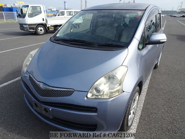 A grey JDM sports car speeding down a highway at night.