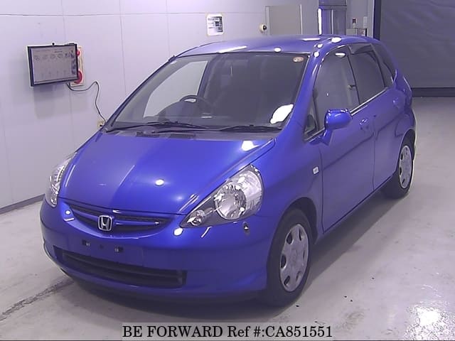 A grey JDM sports car speeding down a highway at night.