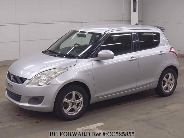 A grey sports car speeding down a highway at night.