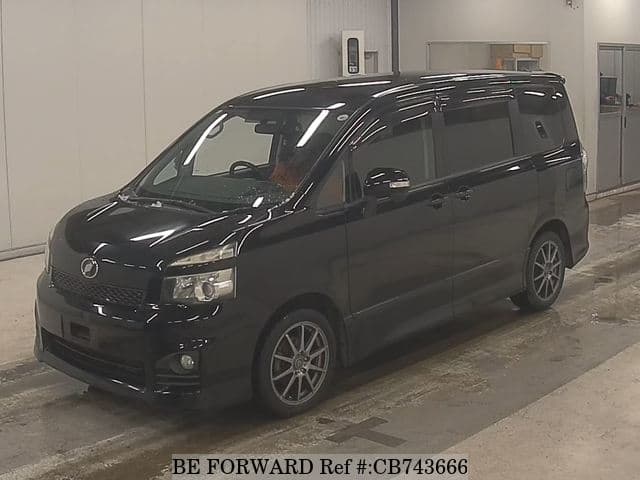 A grey JDM sports car speeding down a highway at night.