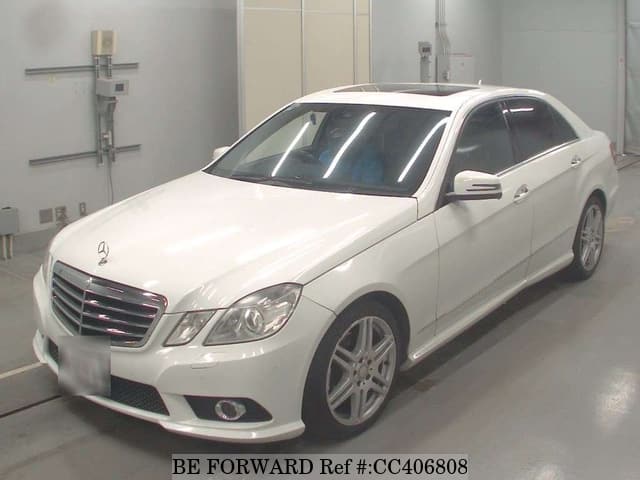 A grey sports car speeding down a highway at night.