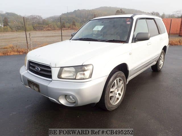 A grey JDM sports car speeding down a highway at night.