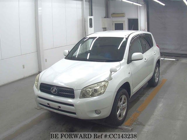 A grey sports car speeding down a highway at night.