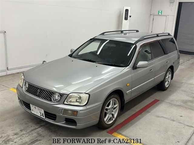 A grey JDM sports car speeding down a highway at night.
