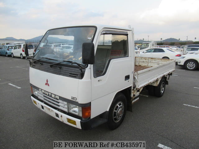 A grey JDM sports car speeding down a highway at night.