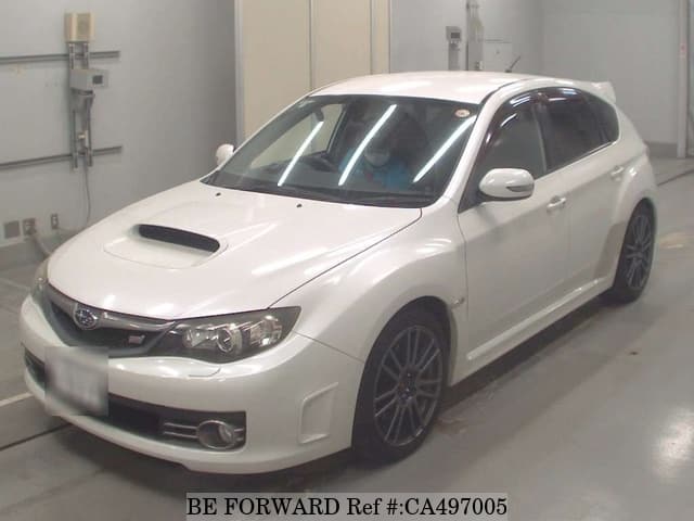 A grey JDM sports car speeding down a highway at night.