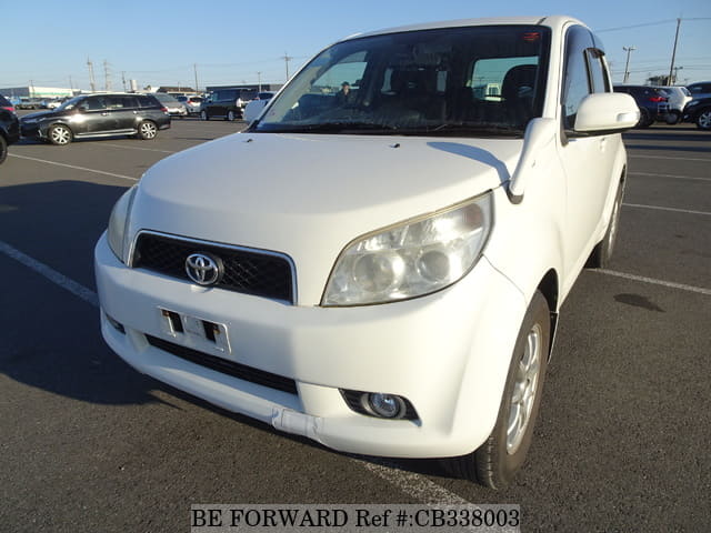 A grey JDM sports car speeding down a highway at night.