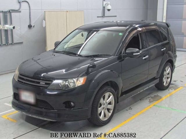 A grey JDM sports car speeding down a highway at night.