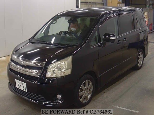 A grey JDM sports car speeding down a highway at night.