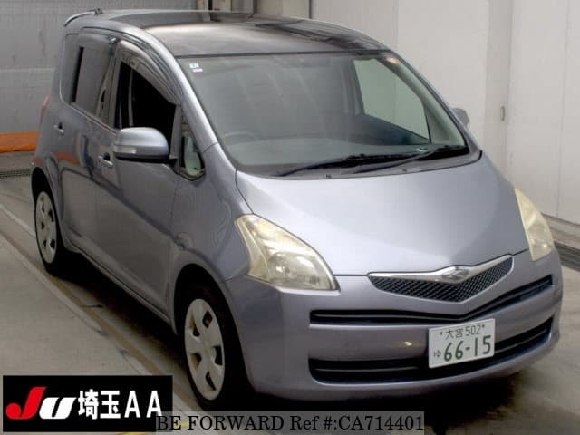 A grey JDM sports car speeding down a highway at night.
