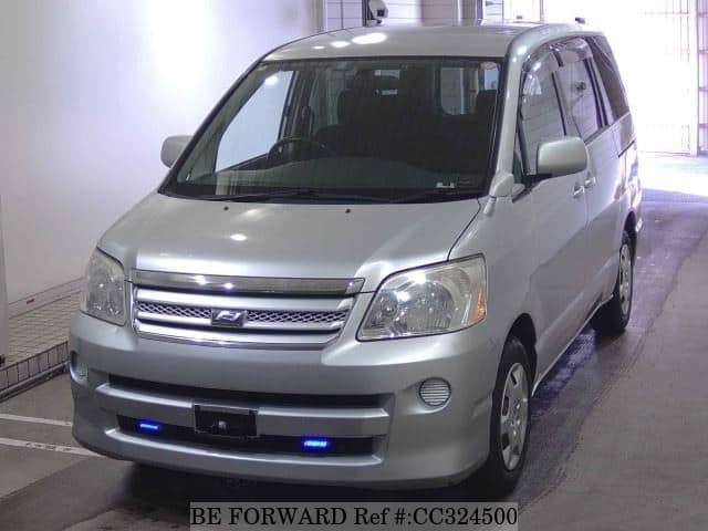 A grey sports car speeding down a highway at night.