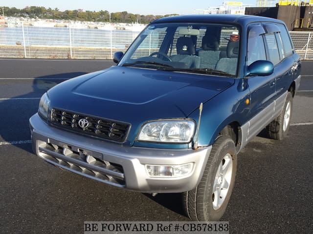 A grey JDM sports car speeding down a highway at night.