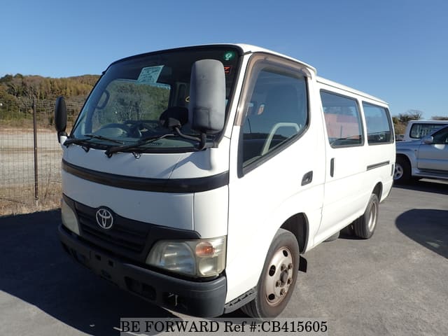 A grey sports car speeding down a highway at night.