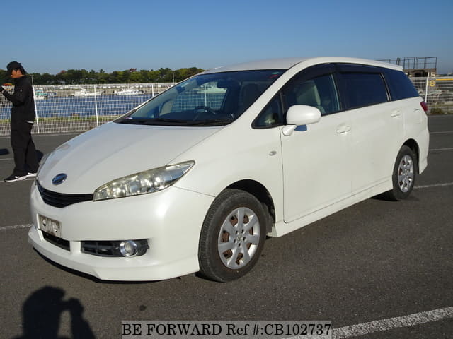 A grey JDM sports car speeding down a highway at night.