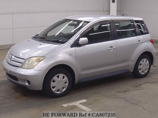 A grey JDM sports car speeding down a highway at night.