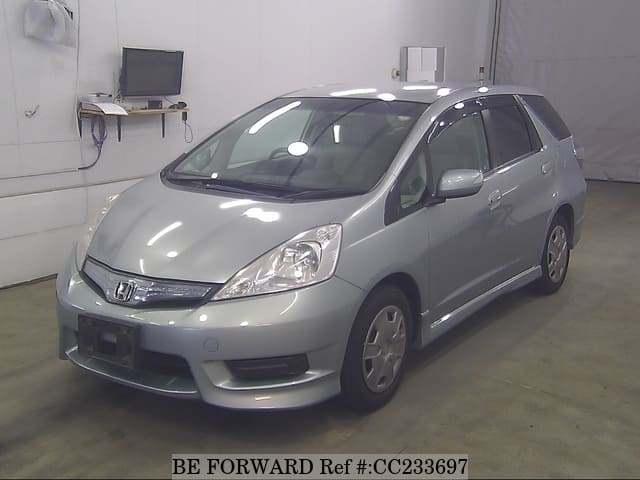 A grey sports car speeding down a highway at night.