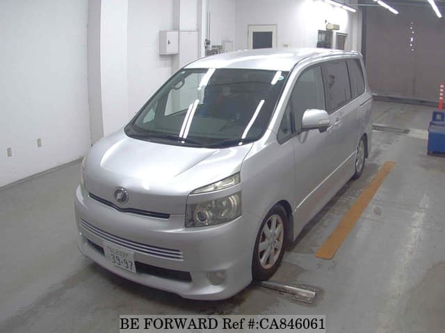 A grey JDM sports car speeding down a highway at night.