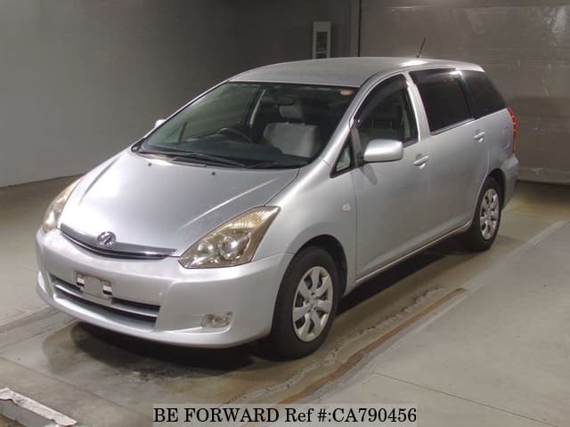 A grey JDM sports car speeding down a highway at night.