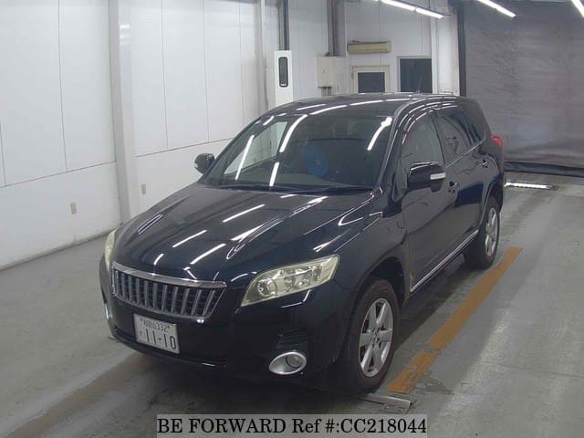 A grey sports car speeding down a highway at night.