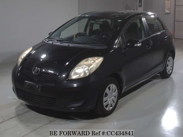 A grey sports car speeding down a highway at night.