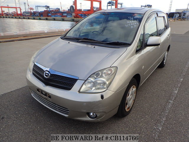 A grey sports car speeding down a highway at night.