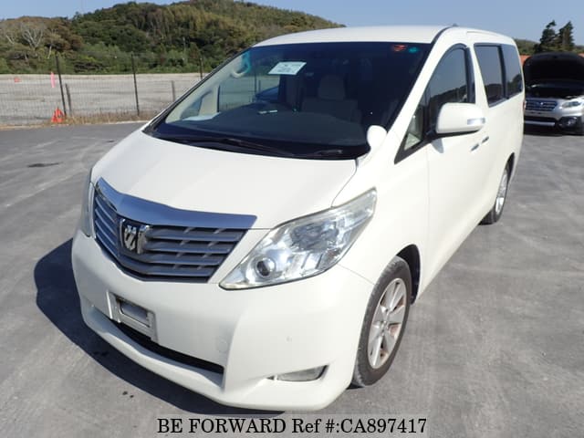 A grey sports car speeding down a highway at night.
